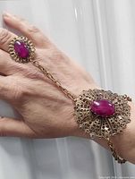 Hand model showing full view of ring linked to bracelet