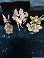 Overview of two fairy figurines and pegasus brooch