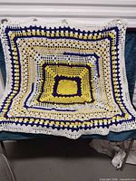 Full view of square crocheted blanket laid flat showing entire pattern