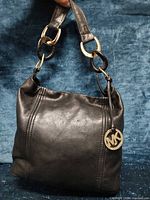 Front view of Michael Kors leather hobo bag showing color, texture, MK charm, chain strap
