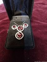 Full view of necklace, earrings and ring set in black presentation box