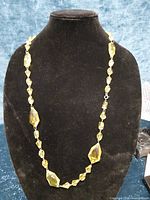 Yellow faceted bead necklace on display bust