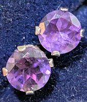 Close-up of both amethyst stud earrings in case