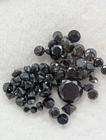 Close-up of assorted loose black diamonds showing sizes and facets