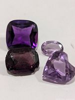 Four faceted amethyst gemstones on white background
