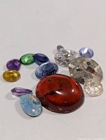 Group view of nine assorted loose gemstones in varied colours and cuts