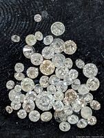 Loose round diamonds spread on black background, various sizes visible