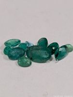 cluster of loose faceted emeralds close-up