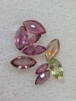 Close view of seven marquise-cut sapphires showing mixed fancy colors