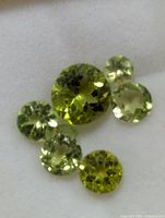 Close-up of six round faceted peridot stones