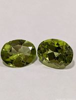 Pair of oval peridot gemstones face-up