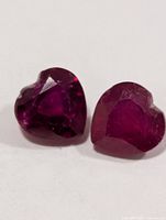 Close-up of the two heart-cut rubies showing color and faceting