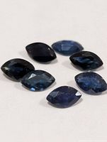 Seven loose marquise sapphires on white background