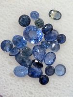 Close view of loose faceted sapphires mixed shapes and shades