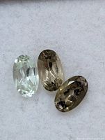 Close-up of three tourmaline gemstones showing colors and cuts