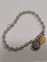 Full view of silver-tone beaded stretch bracelet with labradorite and leaf charms