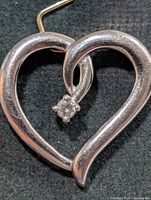 Front view of silver heart pendant showcasing CZ stone