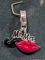 Front view of pendant showing moustache, lips, text and bail