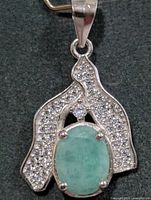 Front view of pendant showing emerald, CZ accents, bail