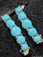 front view showing turquoise cabochons and silver setting