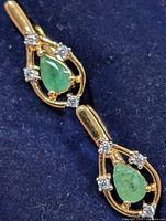 Front view of both earrings in box showing emerald and CZ arrangement