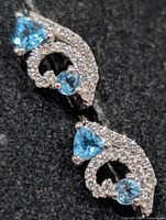 Front view showing blue topaz stones and CZ accents on both earrings