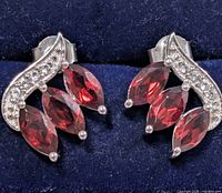 Front view showing garnet arrangement and accent stones on both earrings