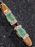 front view showing emeralds and accent stones