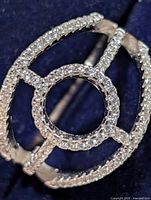 Front view of silver ring showing circular CZ pave center and split shank