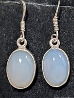 frontal view of both earrings showing oval moonstones and silver hooks