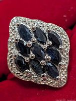 Front view of sterling silver ring with marquise sapphires cluster