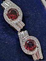 front view of both earrings showing garnet centres and CZ halo