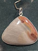 Front view of triangular jasper pendant in silver bezel
