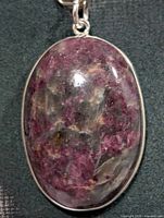 Front view of oval purple agate pendant in silver bezel