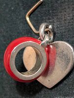 front view showing red enamel bead, silver core, attached heart charm