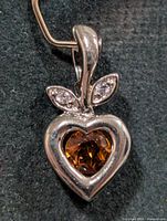 Front view of silver heart pendant with citrine and leaf accents