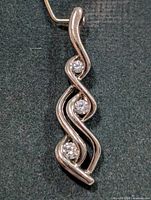 Front view of silver pendant with three cubic zirconia stones