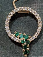 Front view of silver circle pendant with clear and green CZ stones