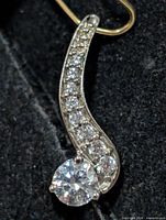 front view of curved silver pendant with CZ stones