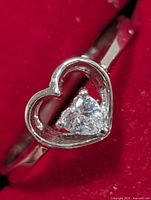 Front view of sterling silver ring showing open heart and CZ