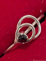 Front view showing garnet stone and double loop setting