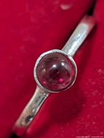 Close-up of garnet cabochon and bezel setting on silver ring