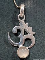 Front view of silver Om pendant with moonstone cabochon