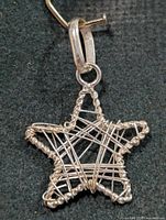 Front view of silver wire star pendant showing twisted frame and criss-cross wires