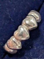 Close-up of heart motifs on silver ring