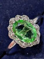 Front view showing green oval stone and halo