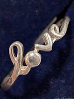 Close-up of ring face showing cursive "love" design