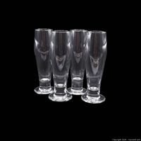 Group shot of four (photo shows five) tall clear crystal pilsner glasses