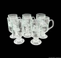 Group of eight etched footed mugs arranged in two rows