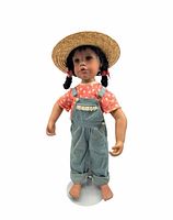 Full front view of porcelain doll on stand